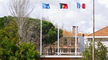 Drapeaux européen, portugais et français hissés à l'entrée du lycée.