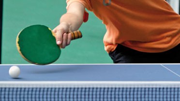 Image d'une élève jouant au ping pong, plan sur la raquette touchant la balle